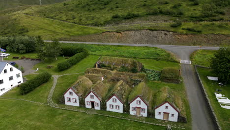 Toma-Aérea-Inclinada-Hacia-Atrás-De-Las-Famosas-Casas-De-Turba-En-Islandia