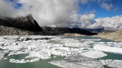 Sobrevuelo-Aéreo-Sobre-Un-Lago-Glaciar-Lleno-De-Icebergs-Derretidos-En-Partes-Remotas-De-Los-Alpes-Suizos-En-Un-Día-Soleado