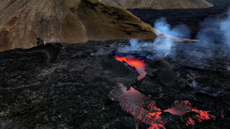 Panoramic-aerial-shot-of-the-hot-lava,-magma-and-ashes-coming-out-of-mouth-of-the-crater-in-Fagradalsfjall,-Iceland