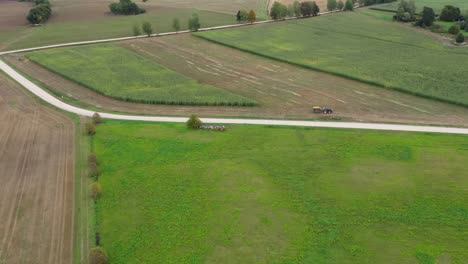 Establishing-aerial-view-of-farmer-driving-tractor-on-a-cornfield