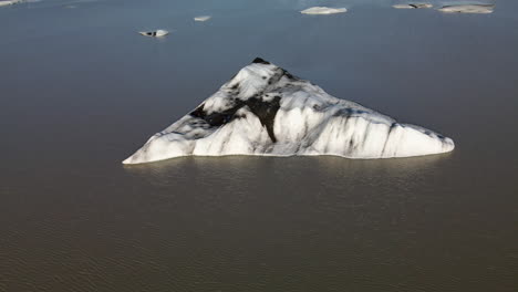 Aerial-circling-shot-of-a-broken-ice-piece-of-a-glacier,-in-Iceland,-Heinabergsjökul
