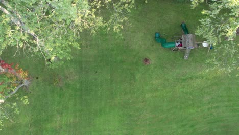 Aerial-drone-bird's-eye-view-over-kids-playing-in-the-playground-on-a-cloudy-day
