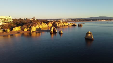 Aerial-view,-4k-drone-shots,-Praia-Dona-Ana-with-cliffs,-Lagos-at-sunrise-in-autumn,-in-the-Algarve,-Portugal