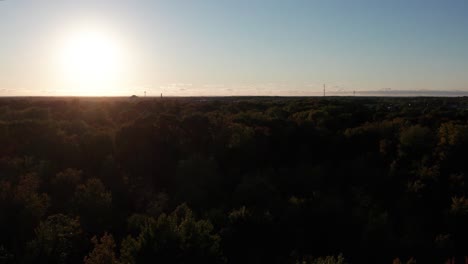 Aerial-drone-shot-over-autumnal-forest-at-sunset