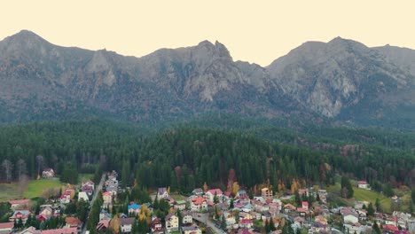 Pequeño-Pueblo-De-Busteni-Con-Densos-Bosques-Y-Montañas-Bucegi-En-El-Fondo-En-Muntenia,-Rumania