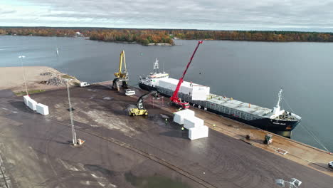 Drone-shot-boat-docked-and-cargo-being-unloaded-at-port