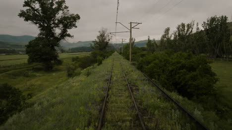 Fly-Over-Disused-Railroad-Covered-With-Green-Meadows-Near-Atskuri,-Georgia