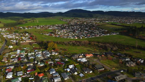 Drone-shot-of-residential-in-rural-area-with-mountain-background-and-blue-sky