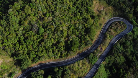 Aerial-top-down-view-of-vehicles-driving-on-winding-mountain-road-to-Da-Lat,-Vietnam