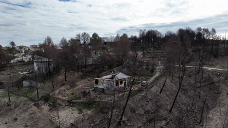 Aerial-view-flying-over-burnt-wreckage-of-family-homes-after-forest-wildfire-blaze