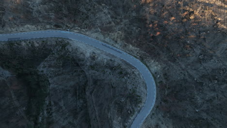 Bird's-Eye-View-Of-Winding-Road-In-Burned-Forest-Area-Of-El-Pont-de-Vilomara,-Spain---drone-shot