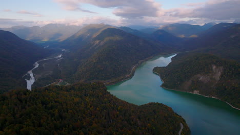 Aerial-view-orbiting-lake-Stausee-surrounded-by-alpine-woodland-Isar-valley