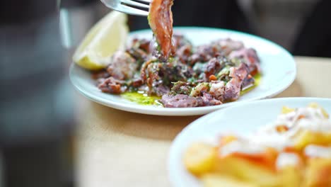 Plate-of-squid-being-eaten-with-a-fork,-Spanish-tapas