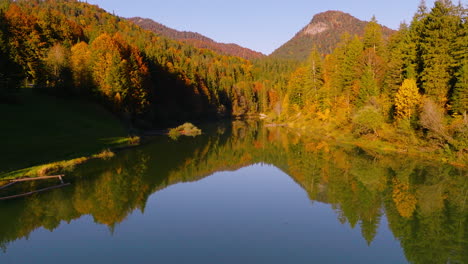 Mirrored-reflections-in-Sylvenstein-Stausee-lake-from-Isar-valley-woodland-with-woodland-mountain-peaks