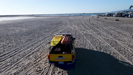 Oceanside-lifeguards-driving-down-the-beach,-aerial-view,-oceanside-harbor