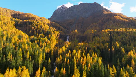 Casere-South-Tyrol-rocky-mountain-peak-surrounded-by-golden-Autumn-alpine-forest-trees