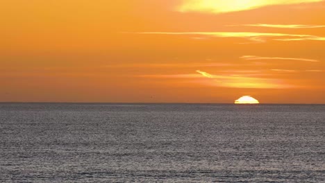 Schöner-Gelber-Sonnenuntergang-über-Einem-Meer-Und-Einige-Wolken-Im-Hintergrund-Am-Strand-Mit-Ruhigen-Wellen