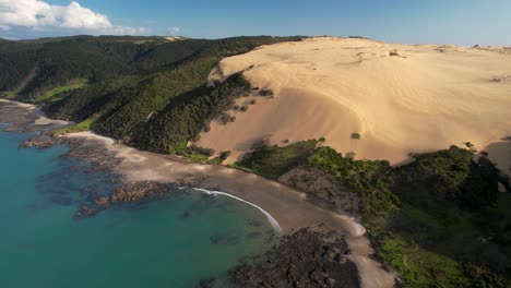 Beautiful-aerial-view-of-huge-sand-dune-in-tropical-forest-and-calm-seaside