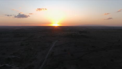 Luftaufnahme,-Die-Bei-Sonnenuntergang-über-Eine-Landschaft-Fliegt