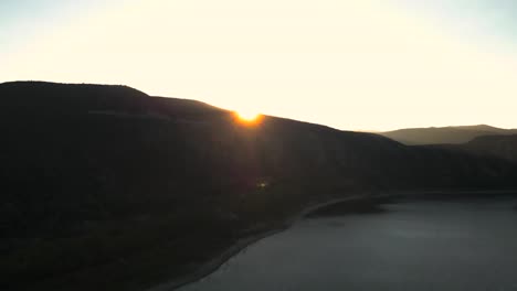 drone-flying-over-Mountain-to-reveal-setting-sun-,-vail-lake-Temecula