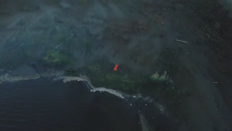 orange-drone-landing-near-water,-vail-lake