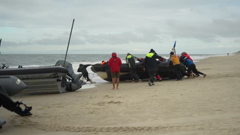 Crew-launching-boat-from-beach-in-Sylt,-Germany