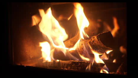 Fire-Wood-put-into-burning-fireplace-close-shot