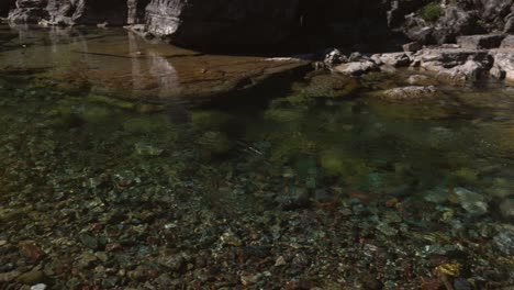 Beautiful-glacier-river-with-clear-water-and-colorful-rocks-in-Glacier-National-Park