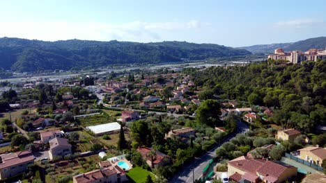 Flying-over-residencial-area-with-houses,-swiming-pools-and-trees-in-Carros,-south-of-france