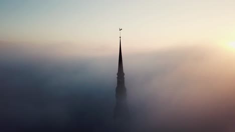 Aerial-drone-view-through-clouds-on-Church-in-old-town-Riga,-Latvia,-Europe