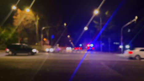 Police-or-ambulance-car-flashing-lights,-traffic-accident,-walking-people,-city-street-in-soft-focus