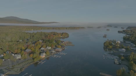 Establishing-aerial-over-Moosehead-Lake,-Greenville-showing-mist-at-dawn