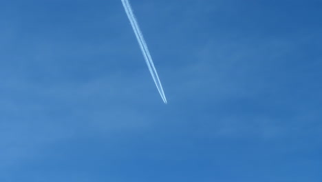 Fernsicht-Auf-Ein-Flugzeug-Im-Flug,-Das-Weiße-Kondensstreifen-Gegen-Den-Blauen-Himmel-Hinterlässt