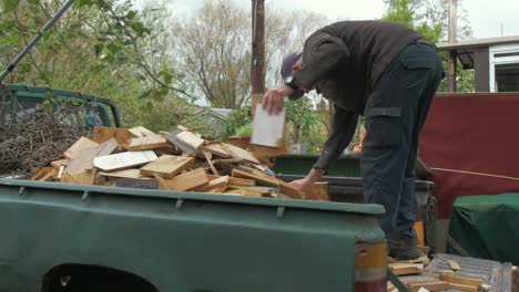 Mature-man-unloading-a-truckload-of-scrap-timber