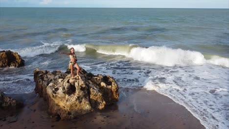Mädchen,-Das-Während-Des-Sonnenuntergangs-Auf-Einem-Felsen-Am-Rande-Des-Brasilianischen-Ozeans-Steht