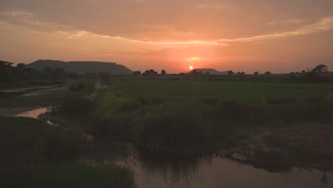 Sonnenuntergang-In-Einer-Hügeligen-Gegend-Von-Gwalior-Mit-Einem-Wasserstrom-Und-Flossenvordergrund