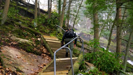 Photographer-and-hiker-walking-up-steps-in-nature