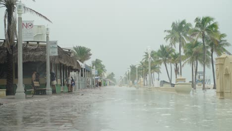 Tormenta-Tropical,-La-Gente-Camina-Por-La-Playa-Vacía-En-Un-Día-Ventoso-Y-Lluvioso