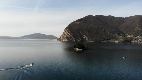 Drohne-Folgt-Dem-Boot,-Das-Sich-Der-Insel-San-Paolo-Auf-Dem-Iseo-see-Nähert