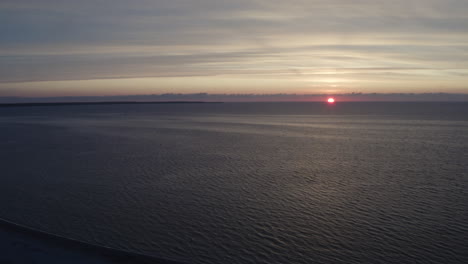 4k-Aerial-shot-of-a-golden-sunset-over-ocean-water