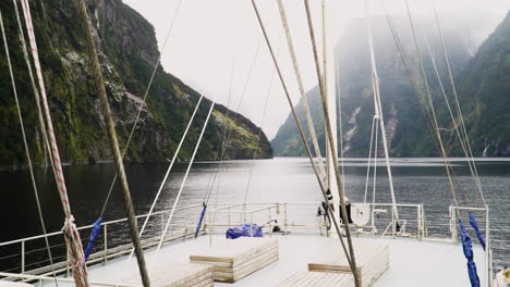 Top-deck-view-of-sailboat-while-sailing-in-majestic-fjords,-New-Zealand