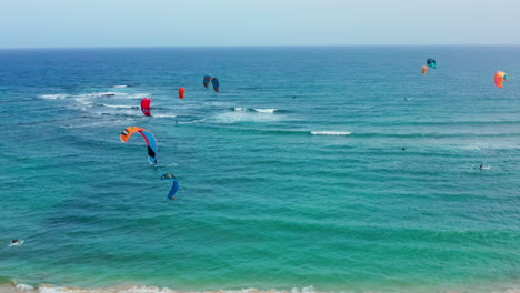 Cinematic-drone-shot-of-professional-kiters-surfing-at-tropical-island
