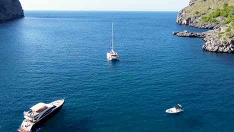 Drone-flying-to-boats-at-Sa-Calobra,-Mallorca