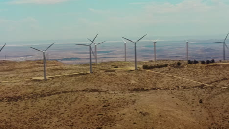 A-panoramic-view-of-the-rows-of-windmills-located-at-the-top-of-the-hill,-which-produce-clean-energy-from-a-renewable-source