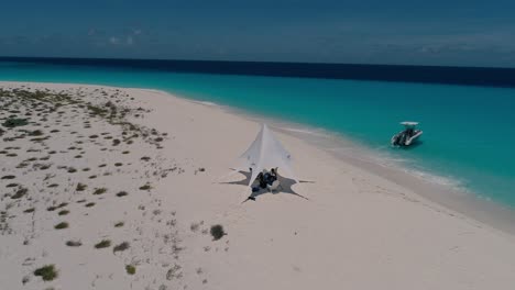Speedboat-and-Luxury-Tent-On-white-sand-beach-caribbean-island,-Glamping-alone-Los-Roques-Venezuela