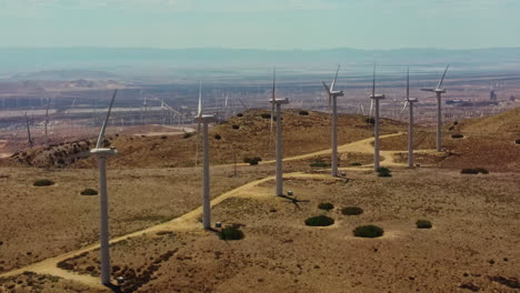 Impressive-view-of-the-endless-wind-farm-at-the-top-of-the-hill-connected-by-a-service-path