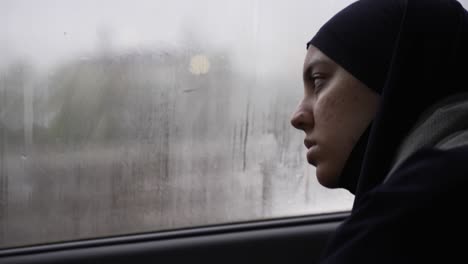 Junge-Muslimische-Frauen,-Die-Hijab-Tragen-Und-Nachdenklich-Aus-Dem-Nebligen-Autofenster-Schauen