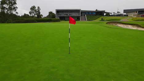 Bandera-Roja-Del-Poste-De-Golf-En-Verde-Bien-Cuidado-En-La-Vista-Estática-Del-Campo-De-Golf