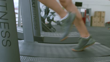 Close-up-of-a-woman-running-on-a-manual-treadmill-at-the-local-gym,-fitness-concept
