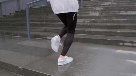 Young-woman-dressed-in-sportswear-running-up-the-stairs-as-an-exercise-for-her-workout-routine